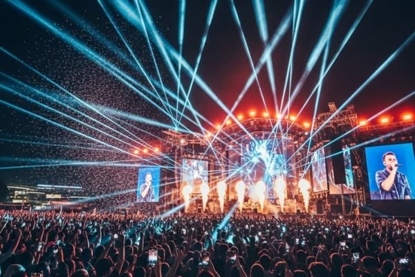 A Concert With A Large Crowd And Bright Lights